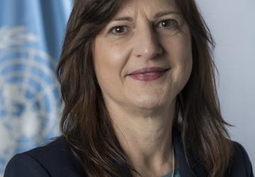Photo officielle de Susana Sottoli, nouvelle Coordonnatrice résidente des Nations Unies en Bolivie, se tenant devant le drapeau de l'ONU.