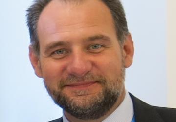 La foto oficial de Zlatan Milišić lo muestra sonriendo frente a un fondo sólido.