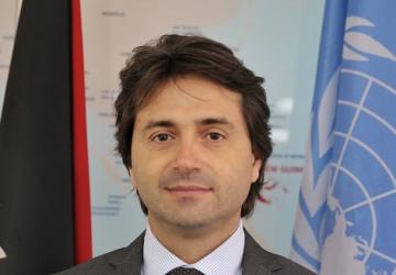 Portrait de Gianluca Rampolla del Tindaro, le nouveau Coordonnateur résident des Nations Unies au Venezuela, avec le drapeau de l'ONU en arrière-plan.