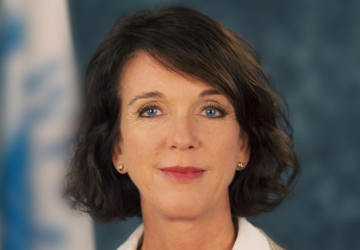 La nouvelle coordonnatrice résidente de l'ONU au Kosovo, la Norvégienne Arnhild Spence, se tient devant un drapeau de l'ONU.