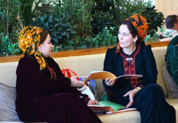 Две женщины обсуждают публикацию на мероприятии.