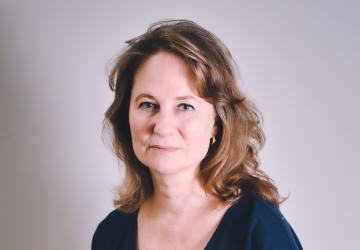 A woman in a dark navy dress with brown hair