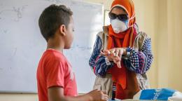 UN staff member provides a young boy safety tips and a hygiene kit.