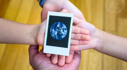 أربع أيدي تحمل صورة الأرض في اليوم العالمي لأمنا الأرض (22 أبريل).