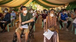 Elder and people with disabilities sit socially distanced and masked as they wait for their vaccinations.