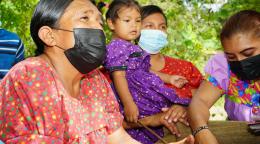 ثلاث نساء من الشعوب الأصلية وفتاة صغيرة في حديقتهم المشتركة.