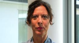 امرأة ترتدي قميصًا أزرق اللون وتبتسم للكاميرا.