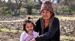 امرأة تجلس مع ابنتها في الفناء الخلفي.