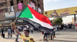 طفل متظاهر يحمل علم السودان في أحد الشوارع في الخرطوم.