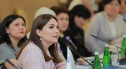 امرأة تجلس في غرفة اجتماعات أمام ميكروفون.