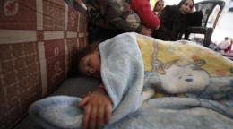 Child sleeping underneath a blanket in Aleppo