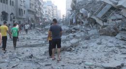 A group of men walk through the rubble of destroyed buildings in Gaza
