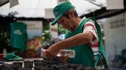 un hombre con sombrero riega las plantas