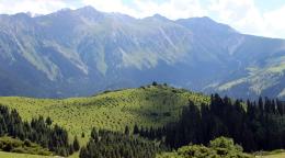 Фотография зеленых гор на фоне голубого неба