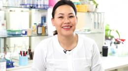 Молодая женщина ученая в лаборатории улыбается на камеру