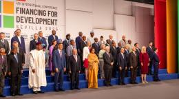 A group of people including the DSG stand in front of a banner