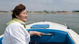 Женщина на моторной лодке плывет по озеру