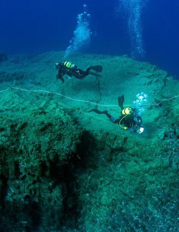 一组科学潜水员在葡萄牙马德拉港圣港的海底评估海洋生物多样性。