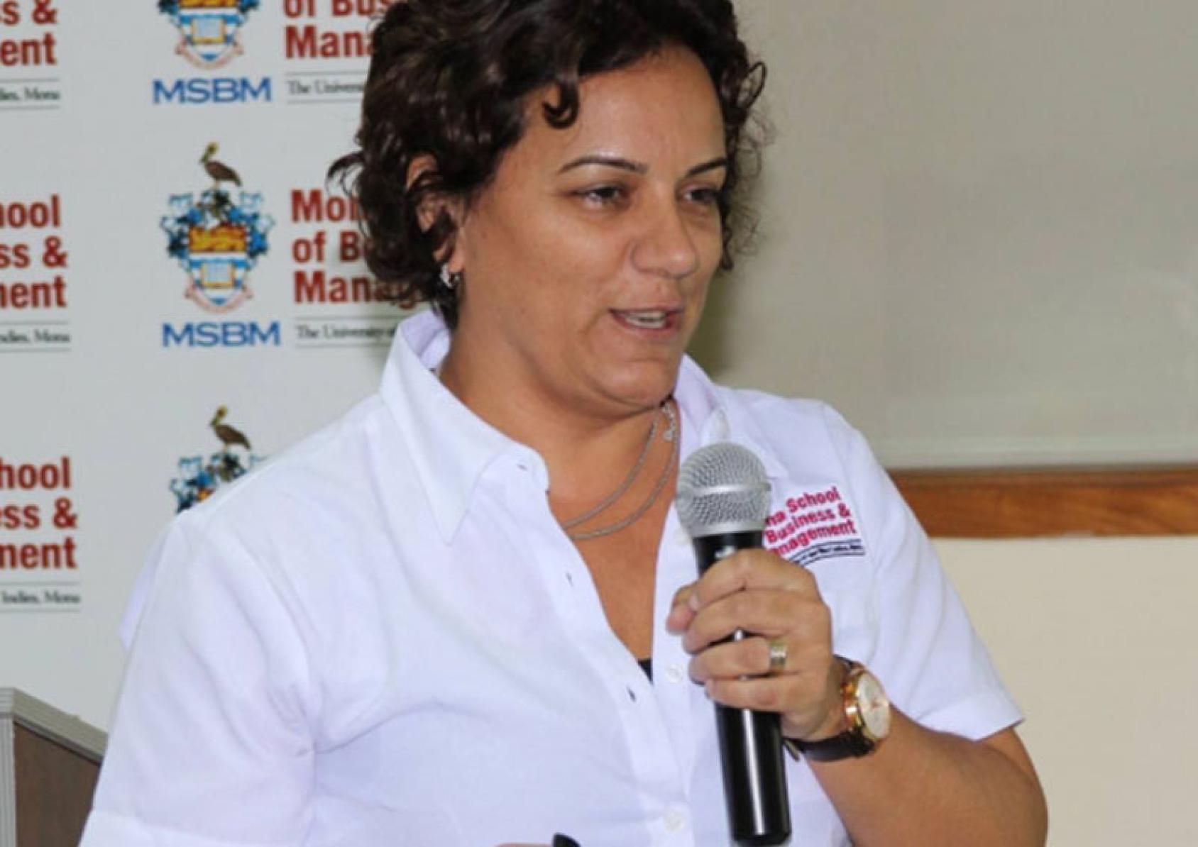 الدكتورة ليلا راو جراهام تتحدث على الميكروفون في إحدى المناسبات.