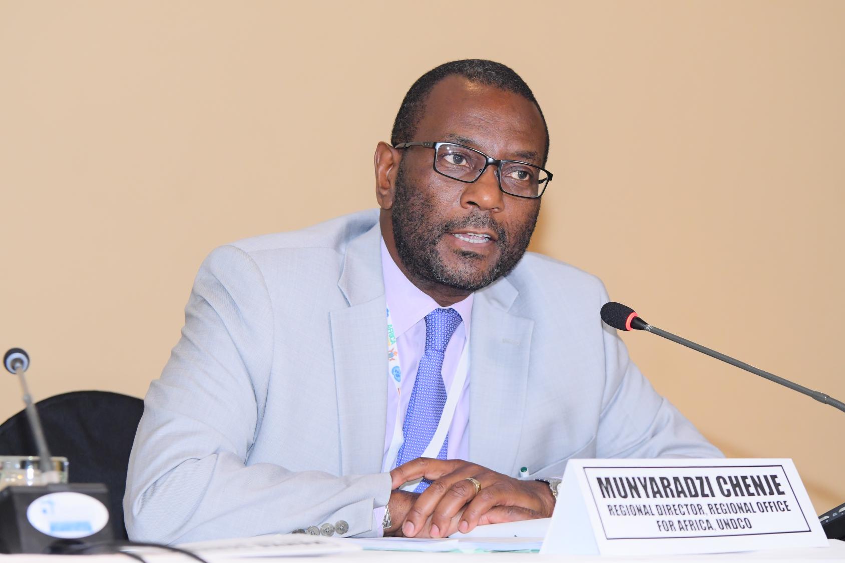 يتحدث السيد تشينجي في مؤتمر أمام ميكروفون.