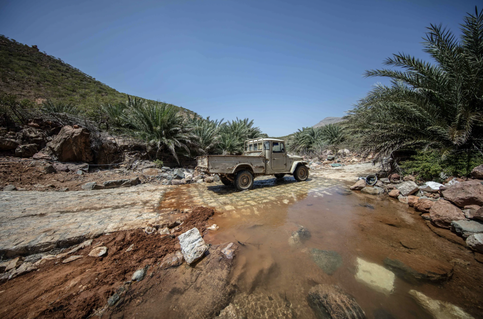 一辆卡车驶过部分被毁的街道。