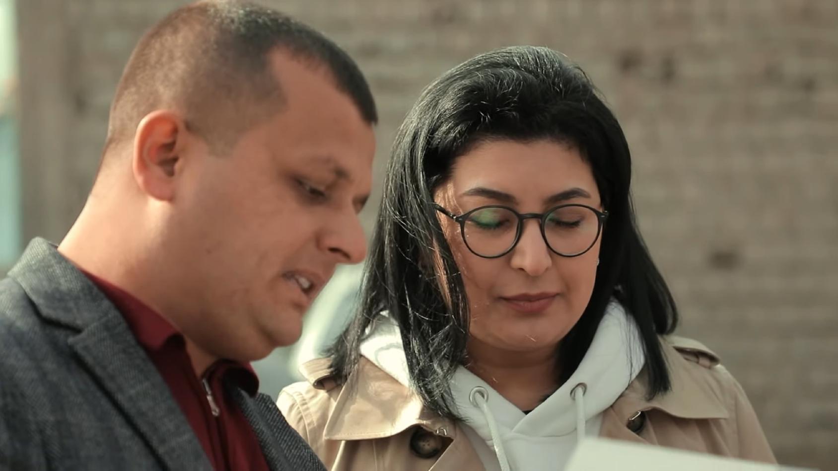 رجل يشارك معلومات من وثيقة مع عقيدة موخيروفا خلال مسيرة.