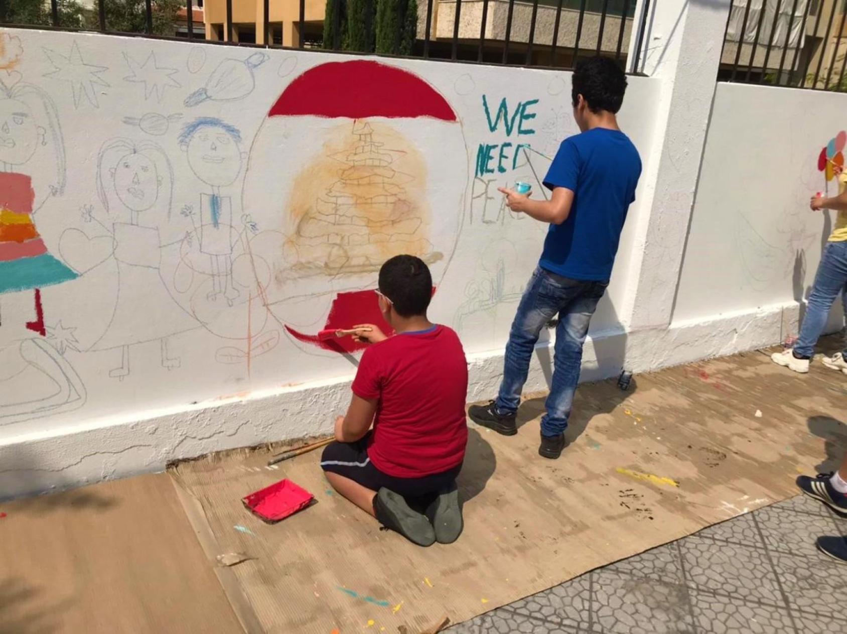 Children painting a mural in the playground of St George Assyrian School in Beirut, which was damaged by the port blasts and rehabilitated by UNESCO.