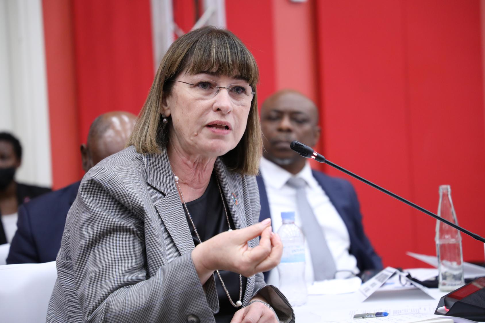 امرأة ترتدي سترة تتحدث أمام الميكروفون.