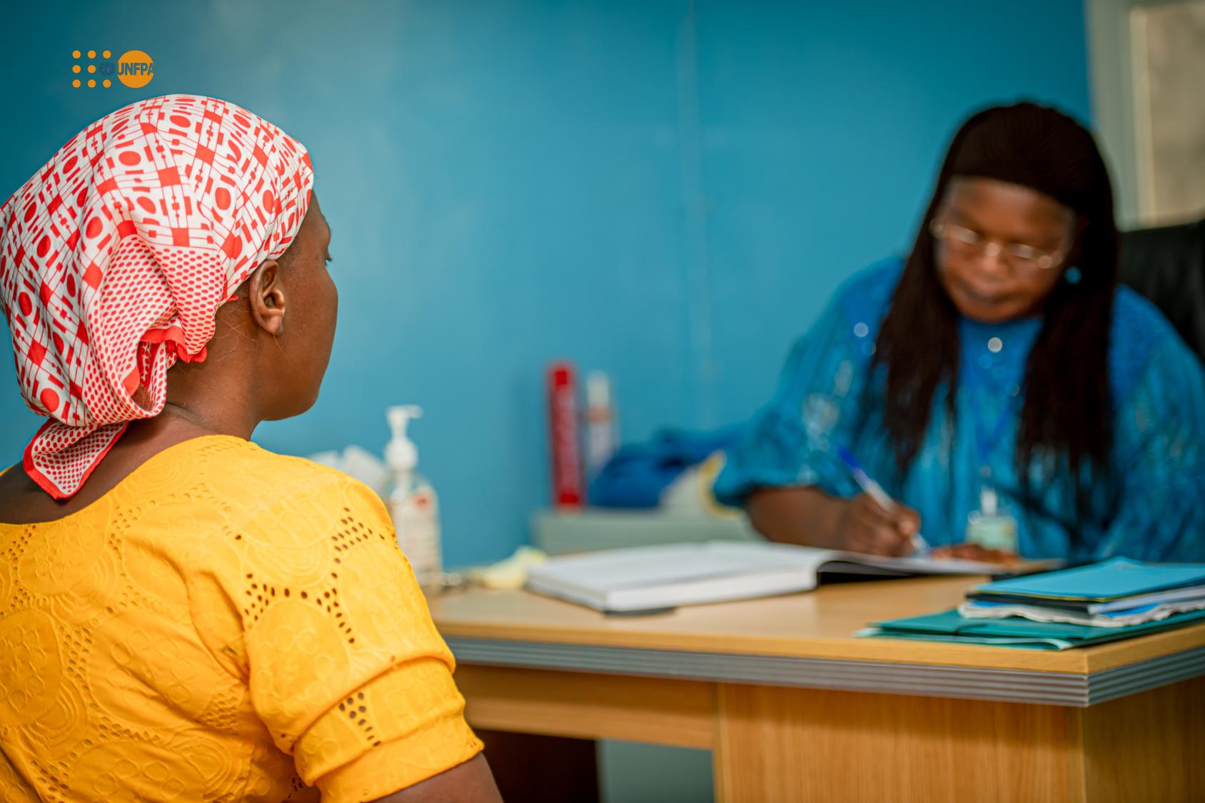  Jeune femme en robe jaune parlant à une femme plus âgée.