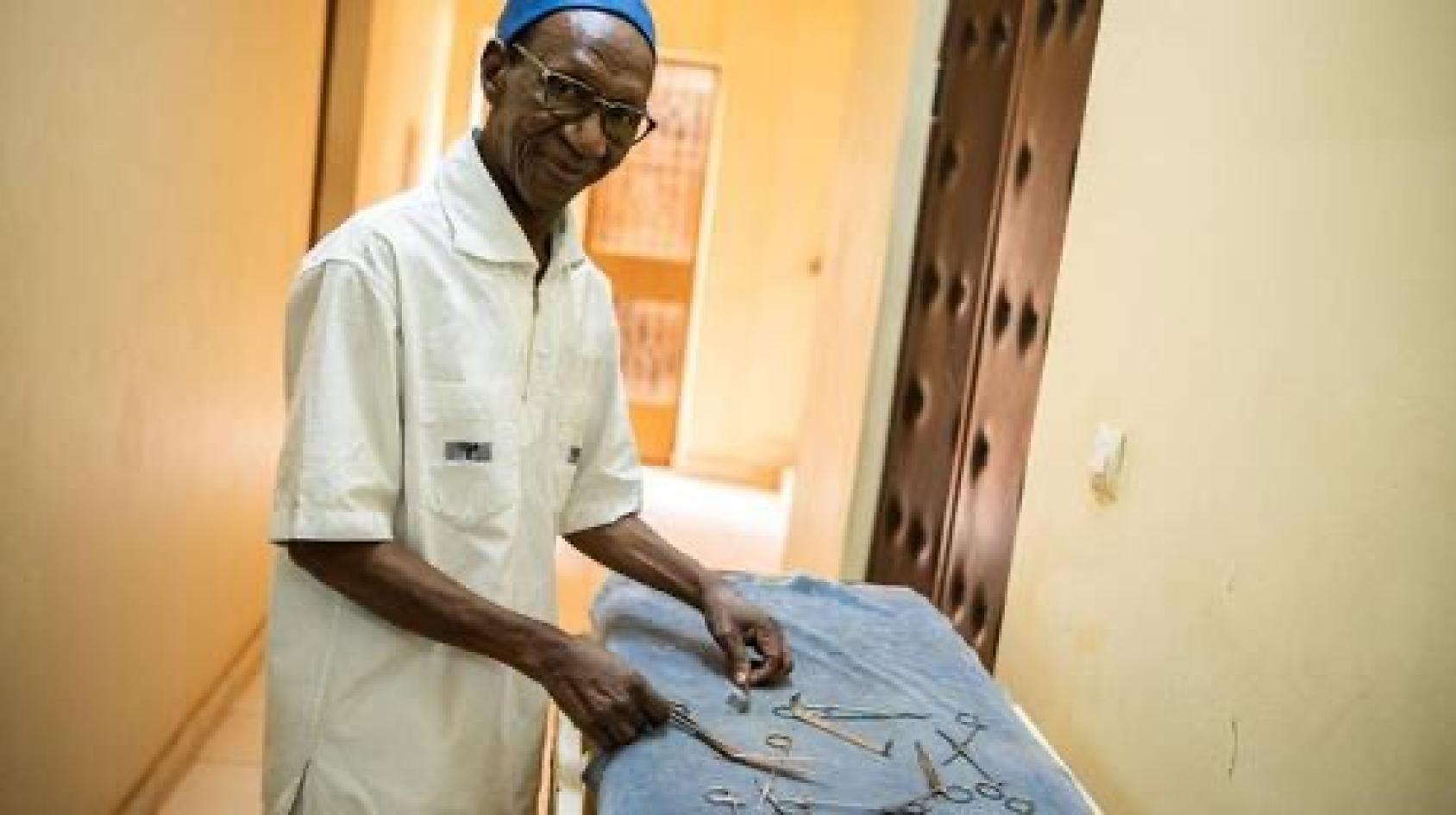 Doctor and Professor Akotiongo holding up medical instruments in a hospital