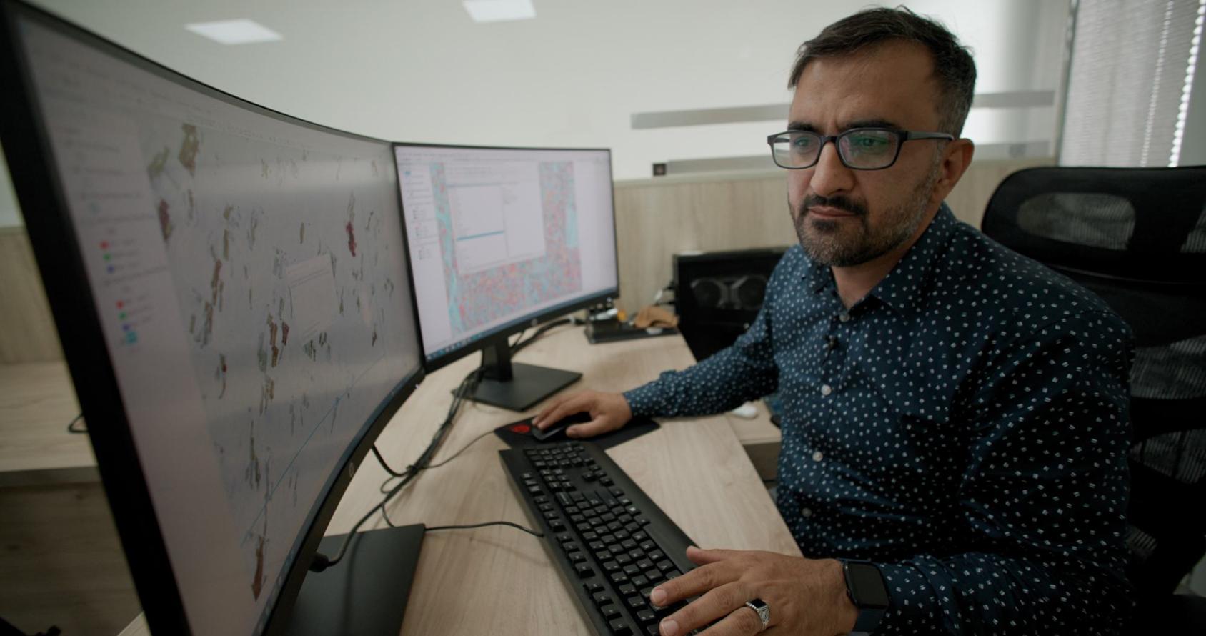 Сотрудник УНП ООН Ахмед Асмати работает за двумя мониторами