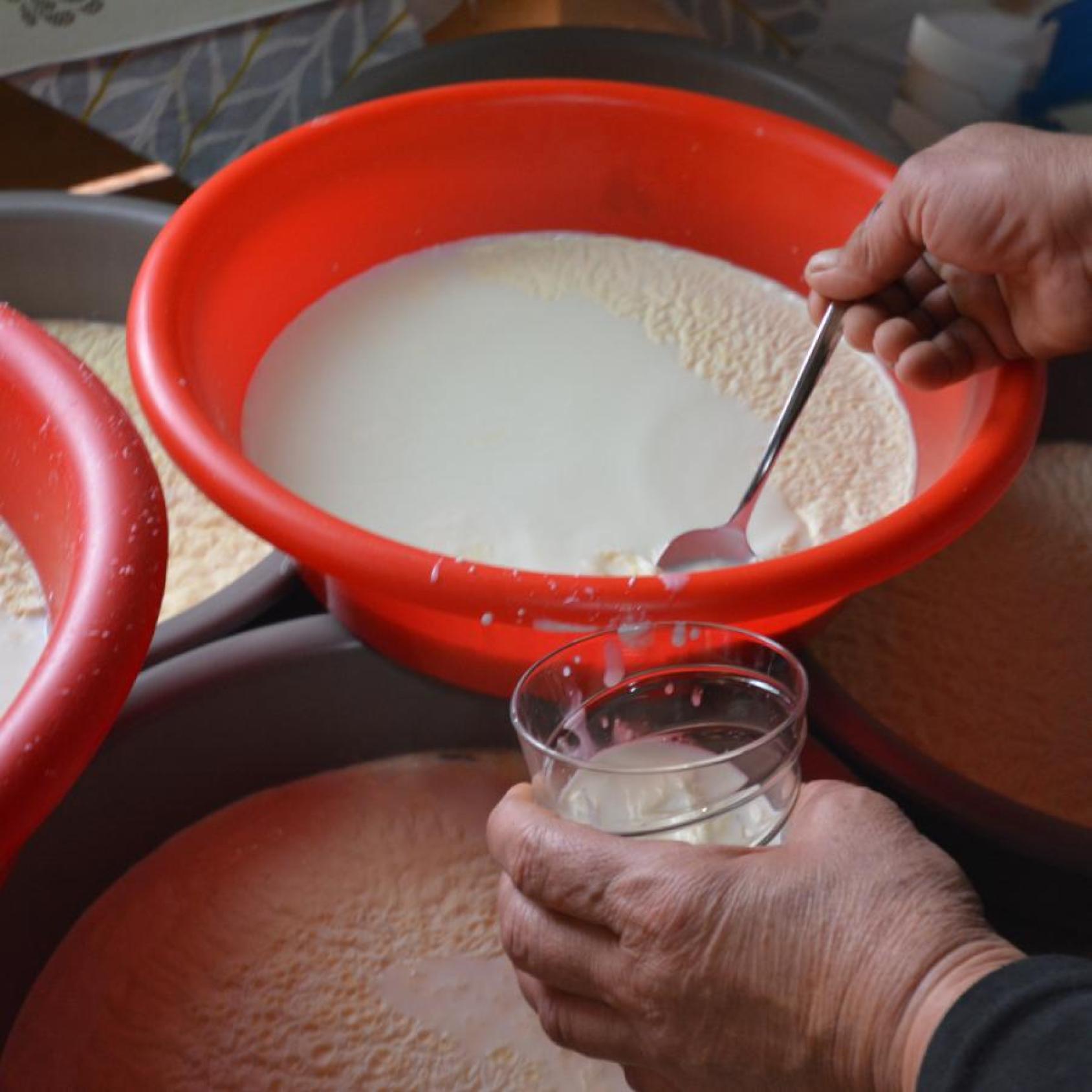 A red tray with milk being decantered with a spoon