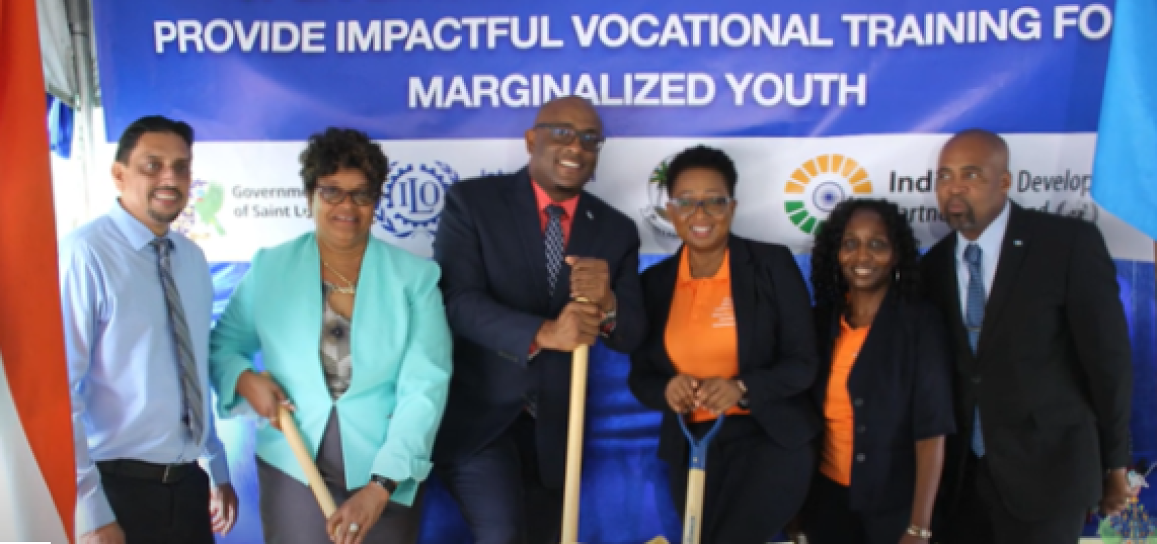 A group of people standing in front of a banner and smiling at the camera