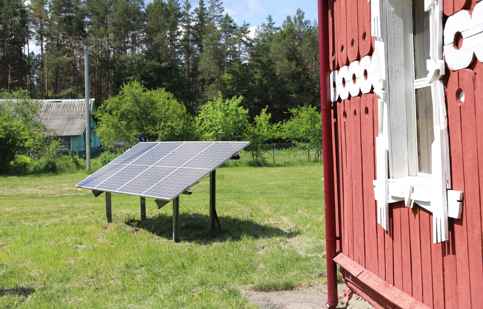 A solar panel near a wooden house