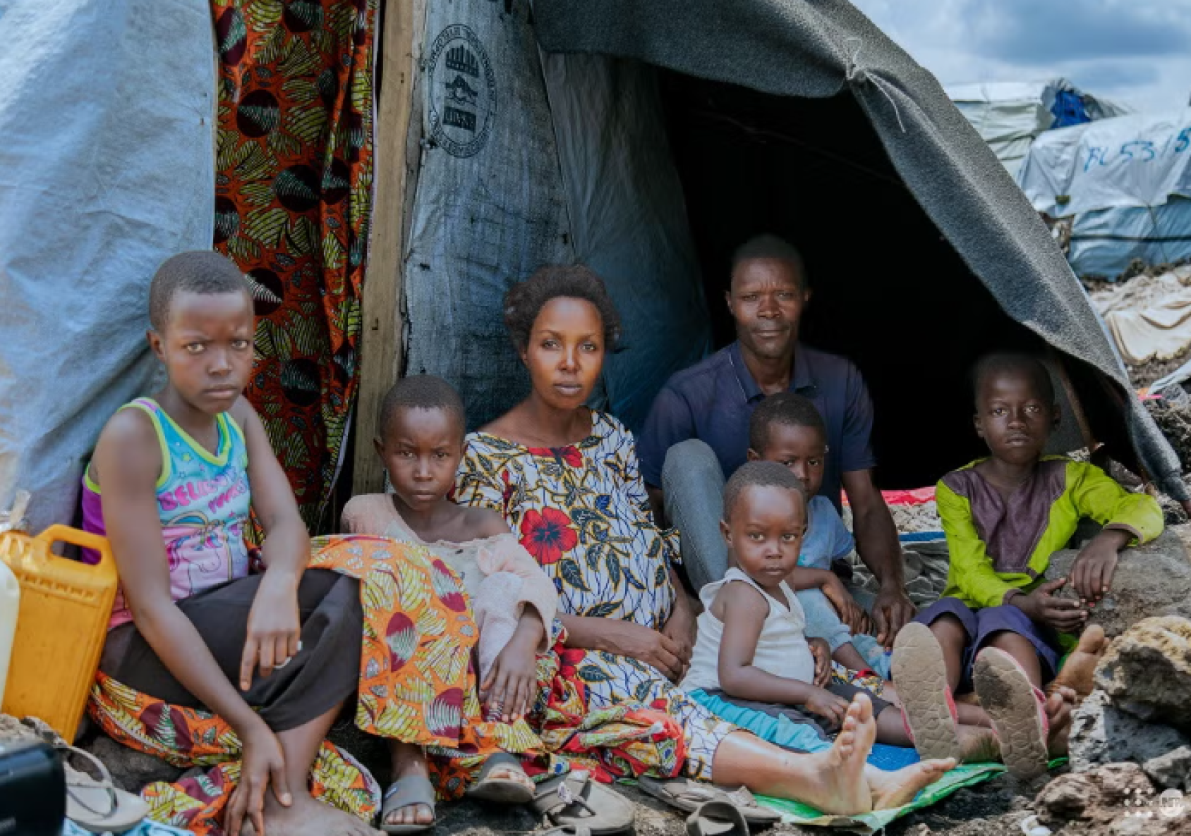 تجتمع أومبيني مع زوجها وأطفالها خارج مأواهم المؤقت في أحد مواقع النزوح غرب غوما، بعد فرارهم من أعمال العنف.