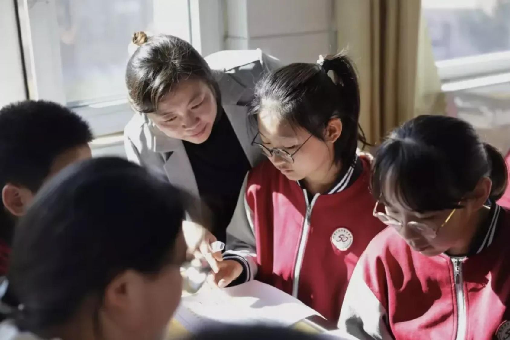 Группа детей и учитель что-то обсуждают