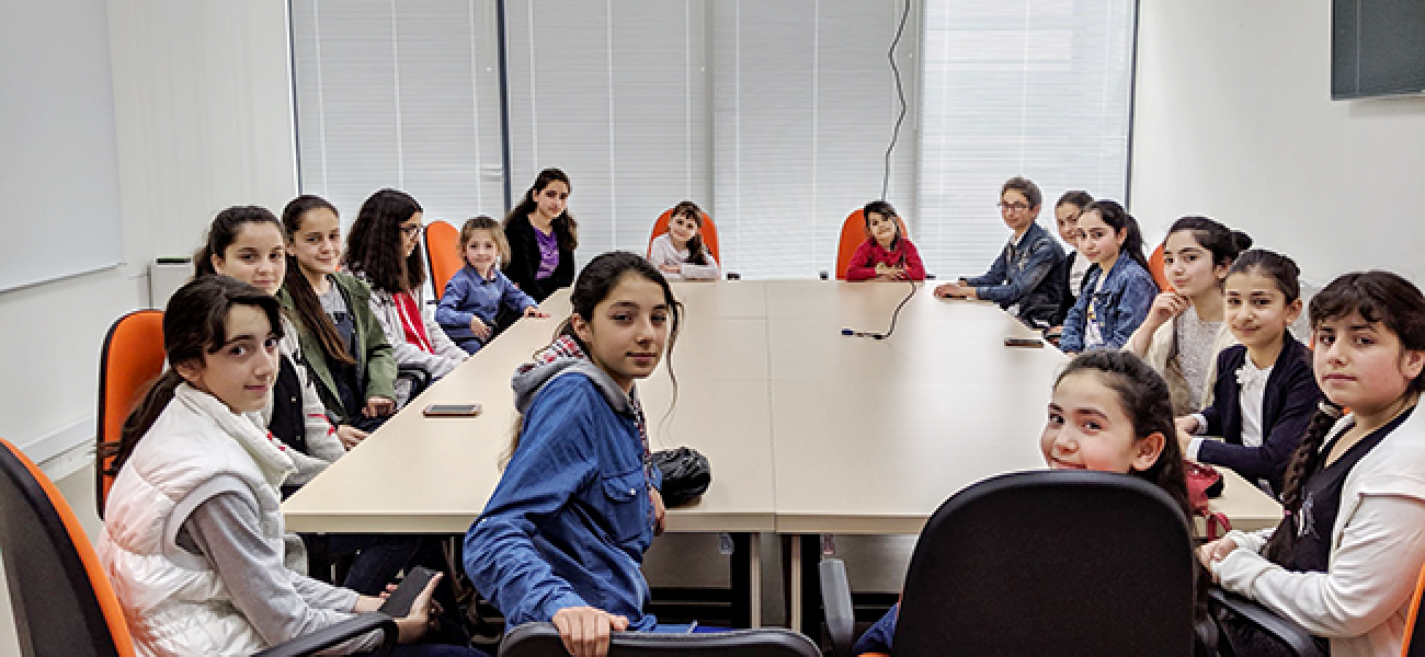 الفتيات يجلسن حول طاولة في غرفة الاجتماعات.