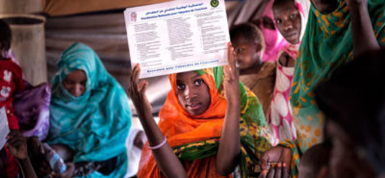 Banner shows a Mauritanian girls holding up a document above her head with other girls surrounding her.