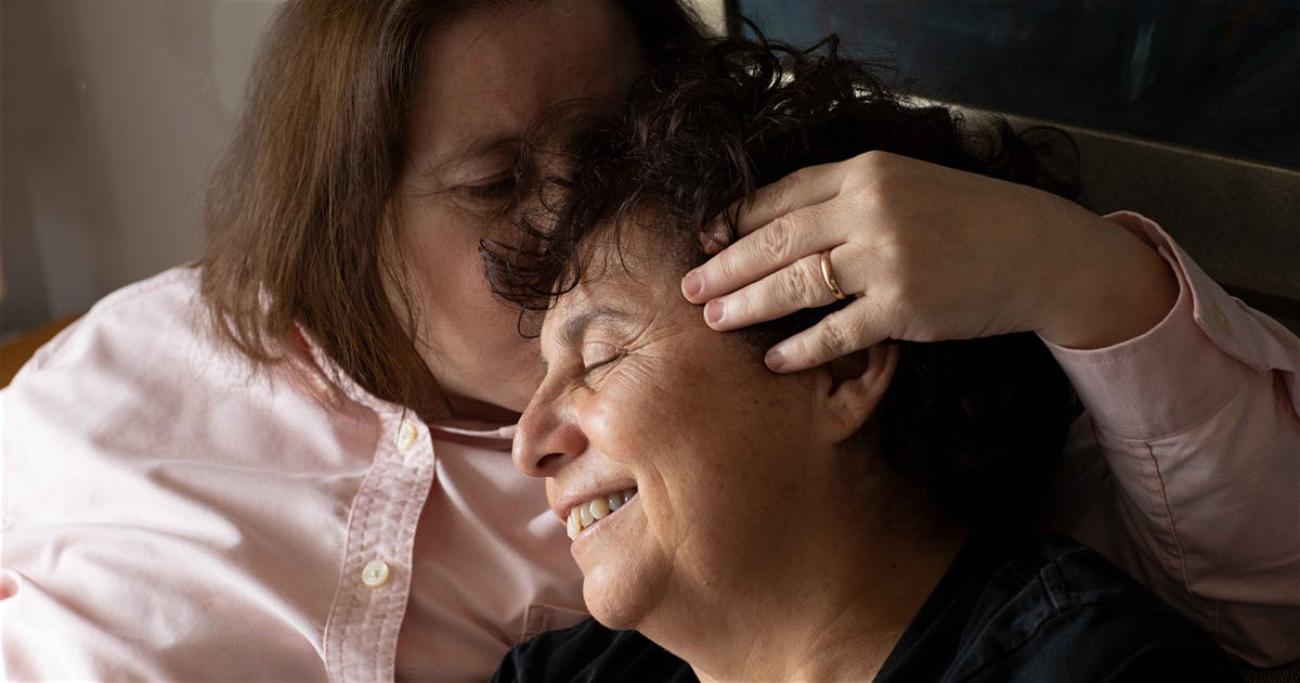 Susel y Gracia se muestran sonriendo, mientras Susel besa a Gracia en la cabeza.