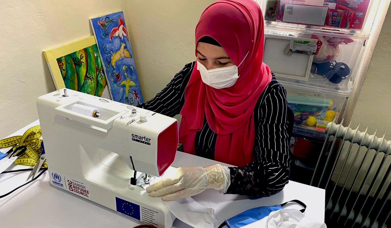 Woman shown sewing protective mask.