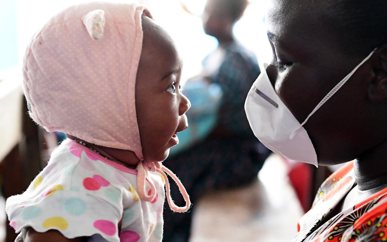 Close up of a woman wearing a protective mask and a female baby.