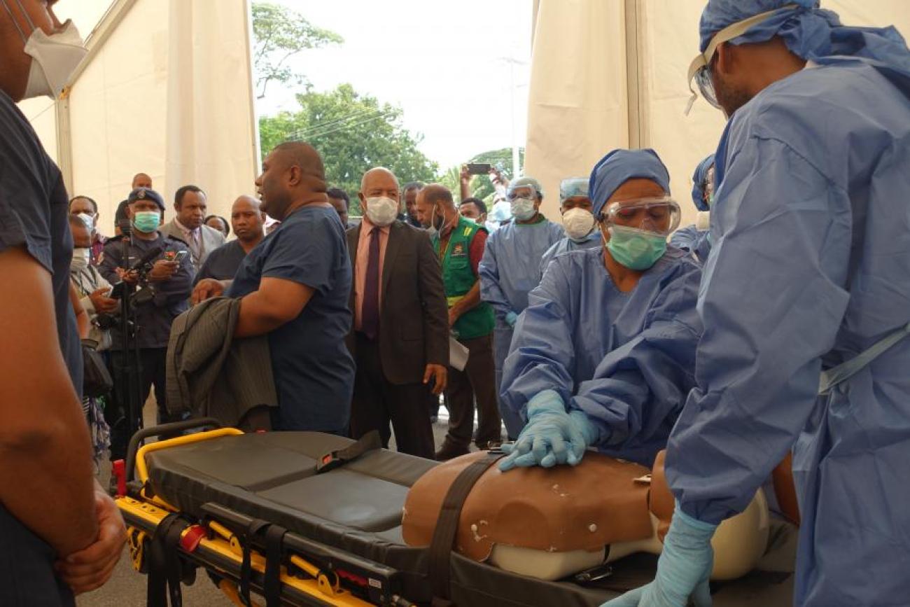 Trabajadores sanitarios practican con un maniquí médico.
