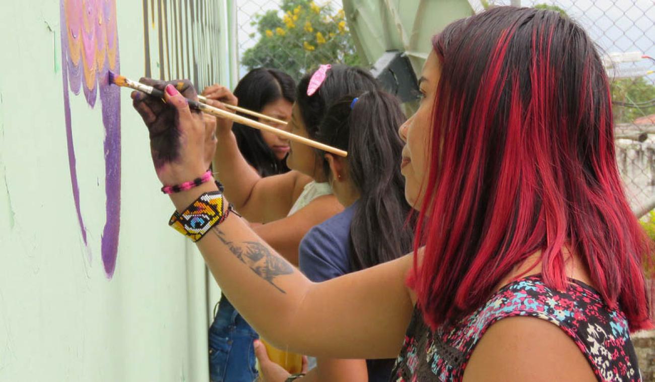 Mujeres en Colombia decoran un muro con mensajes de paz en la localidad de Monterredondo.