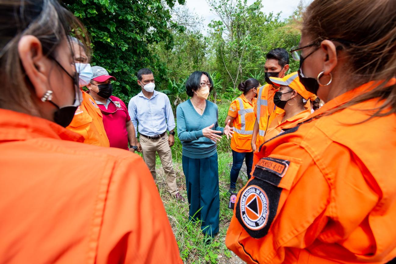 Un grupo de personas formando un círculo en un área verde.