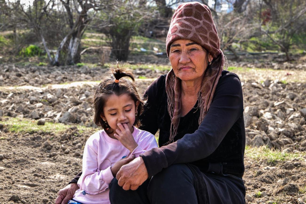 A woman sitting with her daughter in a backyard. 