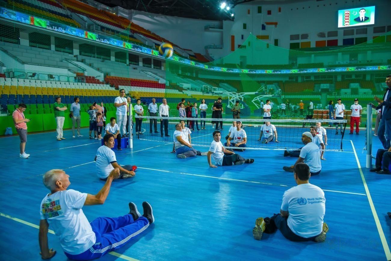 Jugadores con discapacidades jugando al voleibol.