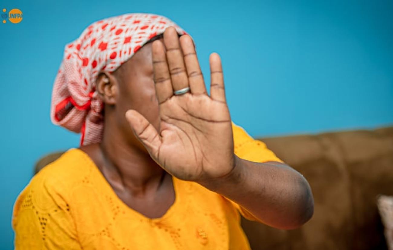 Une jeune femme en robe jaune avec son visage couvert
