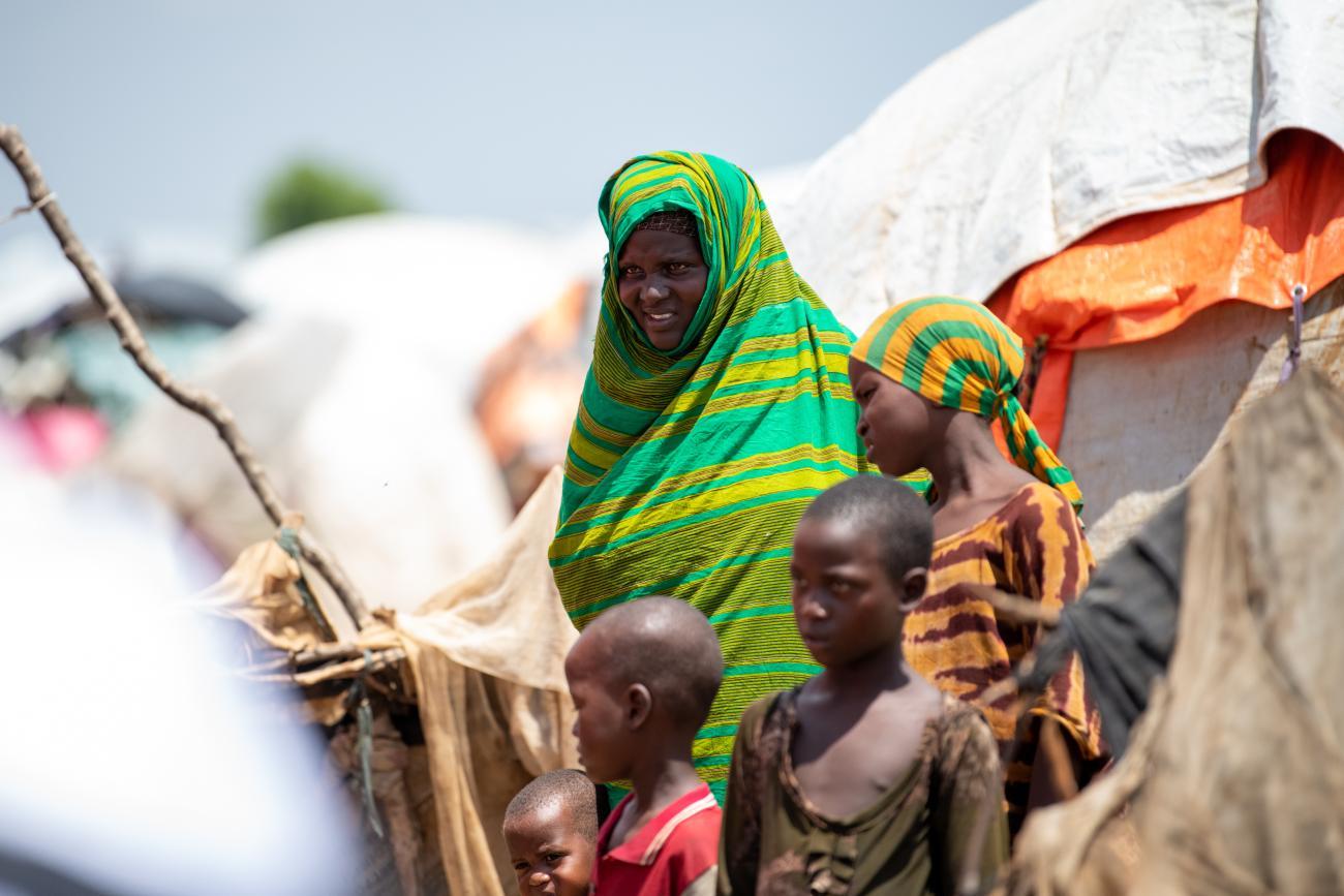 A woman in a green dress with two children by her side in Somalia