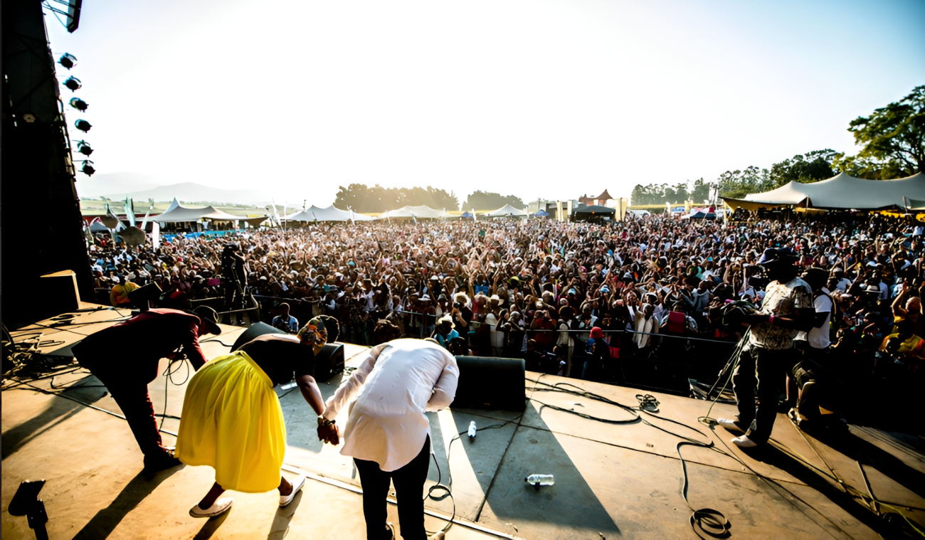 Three people on stage are bowing towards the audience