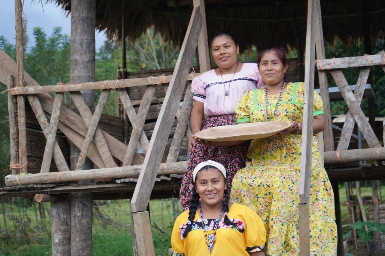 Three women in an outdoor setting looking at the camera and smiling